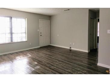 Spacious living room featuring wood-look flooring and a bright window, perfect for natural light at 2566 Stratford Ln, Morrow, GA 30260