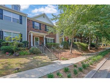 Charming townhomes with brick accents, manicured lawns, and welcoming front entrances at 833 Society Ct, Woodstock, GA 30188