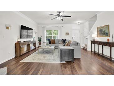 Bright living room with hardwood floors, neutral tones, and modern furnishings, with a large sectional sofa at 833 Society Ct, Woodstock, GA 30188