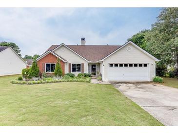 Charming single-story home with well-manicured lawn and landscaping at 992 Harbins Pass Dr, Dacula, GA 30019