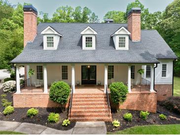 Charming two-story home featuring a brick foundation, inviting front porch with classic columns, and well-manicured landscaping at 5588 Rhododendron Trl, Douglasville, GA 30135