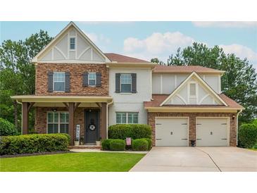 Charming two-story home featuring a manicured lawn, stone accents and a two-car garage at 4840 Chase Ln, Cumming, GA 30040