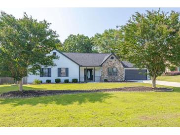 Charming single-story home with stone accents, well-maintained lawn, and mature trees at 1510 Summer Lake Ter, Loganville, GA 30052