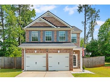 Charming two-story brick home with a two-car garage and neatly landscaped front yard at 154 Stephens Mill Dr, Dallas, GA 30157