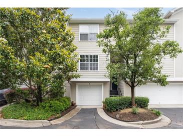 Charming townhome exterior features an attached garage, mature trees, and well-maintained landscaping at 4248 River Green Dr # 305, Atlanta, GA 30327