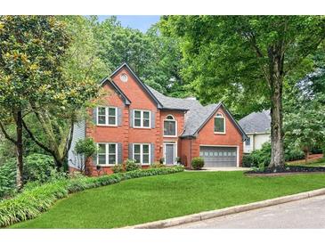 Charming two-story brick home featuring a manicured lawn and attached two-car garage at 2220 Cape Courage Way, Suwanee, GA 30024