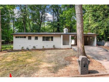 Charming single-story home with a white brick exterior and a well-manicured front yard at 276 Lydia Se Dr, Atlanta, GA 30315