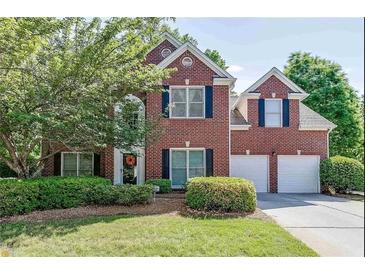 Charming two-story brick home with a well-manicured lawn and a two-car garage at 1008 Post Horn Run, Lawrenceville, GA 30045