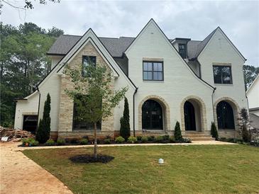 Stunning two-story home featuring white brick, stone accents, arched entryways and a meticulously landscaped front yard at 344 Michael Dr, Alpharetta, GA 30009