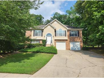 Charming two-story brick home featuring a well-manicured lawn and a two-car garage at 5619 Wandering Vine Se Ln, Mableton, GA 30126