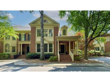 Charming brick townhome featuring a welcoming entrance, front porch, and manicured landscaping at 2010 Riverside Rd, Roswell, GA 30076