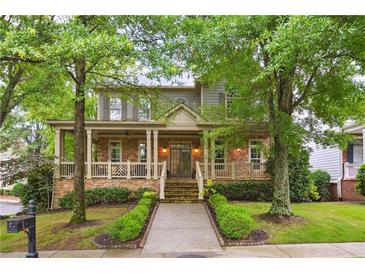 Charming two-story home with a welcoming front porch, stone accents, and lush landscaping at 2112 Murren Se Dr, Smyrna, GA 30080