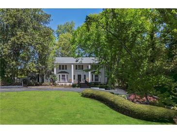 Stately home featuring a large front lawn, mature trees, and a columned front porch at 1011 W Paces Ferry Nw Rd, Atlanta, GA 30327