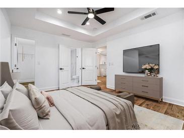 Bright bedroom with a ceiling fan, ensuite bath, and a large TV at 904 Fairburn Nw Pl, Atlanta, GA 30331