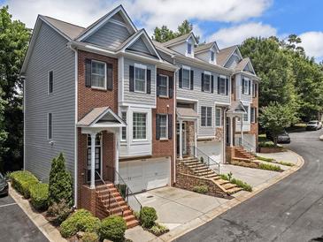 Charming townhomes showcasing a mix of brick and siding, each featuring private garages and inviting front entrances at 1251 Brickton Nw Dr, Atlanta, GA 30318