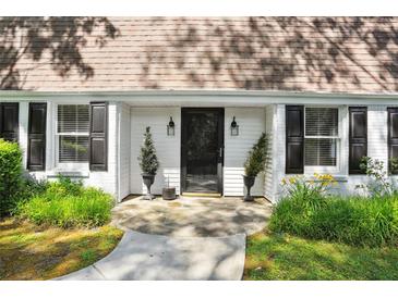 Inviting front door with classic black shutters and beautiful landscaping at 4234 Long Branch Ct, Brookhaven, GA 30319