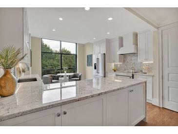 Bright kitchen features white cabinets, granite countertops, stainless steel appliances, and a breakfast nook with a view at 750 Park Ne Ave # 6E, Atlanta, GA 30326