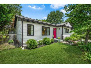 Charming one-story home with white siding, black trim, lush lawn and a bright pink front door at 2296 N Shallowford Rd, Atlanta, GA 30341