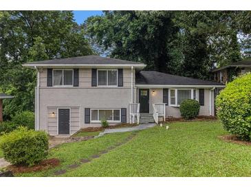 Charming home with brick facade, complemented by a lush green lawn and mature trees at 2083 Green Forrest Dr, Decatur, GA 30032