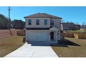 Charming two-story home with a well-maintained lawn, long driveway, and attached two-car garage at 301 Amsterdam Way, Hampton, GA 30228