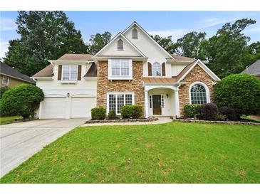 Charming two-story home featuring stone accents, a well-manicured lawn, and a two-car garage at 4360 Canterbury Walk Dr, Duluth, GA 30097