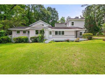 Expansive backyard featuring lush lawn, mature trees, and a charming back deck for outdoor living at 6771 Sunny Brook Ln, Atlanta, GA 30328