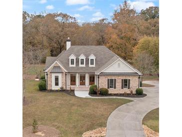 Charming home featuring a brick facade, inviting front porch, and a well-manicured lawn at 100 Percheron Dr, Canton, GA 30114
