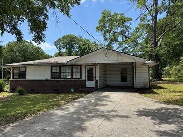 Modest single-story home featuring a brick foundation, light-colored siding and a covered entrance at 6380 Mableton Sw Pkwy, Mableton, GA 30126
