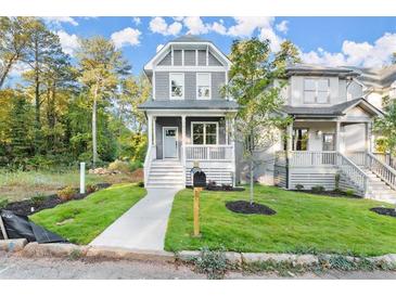 Charming two-story home with a welcoming front porch and a well-manicured lawn at 1697 Thomas St, Decatur, GA 30032