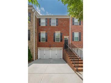 Charming brick townhome with a two-car garage, black shutters, and a well-maintained brick stair entry at 2264 Ewell Park Dr, Lawrenceville, GA 30043