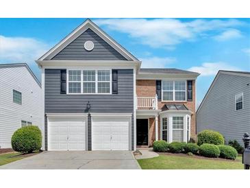 Charming two-story home featuring a combination of brick and blue siding, plus a two-car garage and manicured landscaping at 535 Watercress Dr, Woodstock, GA 30188