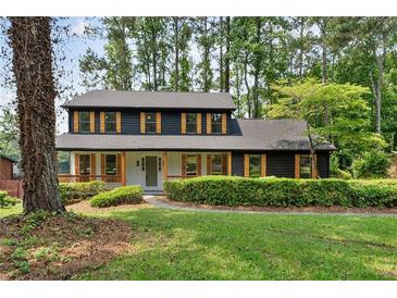 Charming two-story home with dark siding, light trim, and a landscaped front yard, creating excellent curb appeal at 5759 Albans Way, Lithonia, GA 30058