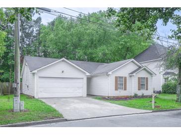 Charming single-story home features a two-car garage, lush lawn, and beautiful landscaping at 5779 Wellborn Creek Dr, Lithonia, GA 30058