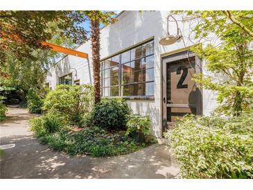 Charming building exterior featuring industrial windows, lush landscaping, and a welcoming entrance at unit number two at 820 Dekalb Ne Ave # 2, Atlanta, GA 30307