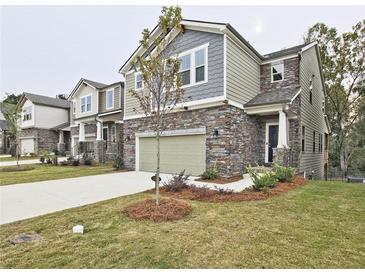 Beautiful two-story home featuring stone accents, a two-car garage, and manicured lawn at 3305 Morgan Rd, Buford, GA 30519