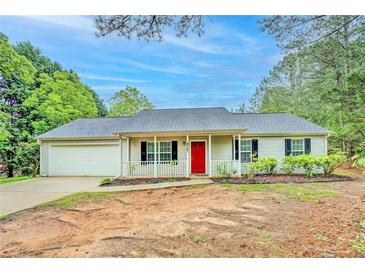 Charming single-story home with a red front door and a well-maintained front yard at 4547 Atha Cir, Loganville, GA 30052