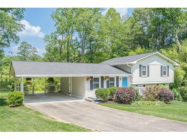Charming two-story home with carport, manicured lawn, and mature trees create a welcoming curb appeal at 205 Plantation Sw Rd, Smyrna, GA 30082