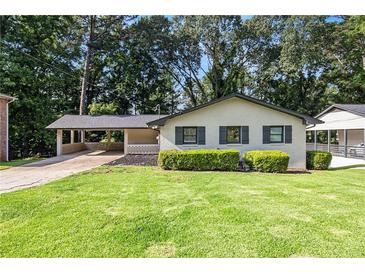 Charming single-story home with a well-manicured lawn and attached carport at 1749 W Caribaea Se Trl, Atlanta, GA 30316