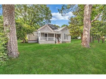 Charming one-story home featuring a cozy front porch and a lush green lawn at 3961 Jodeco Rd, Mcdonough, GA 30253
