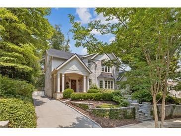 Charming stone home with manicured front yard, columns, and inviting entryway at 54 Camden Ne Rd, Atlanta, GA 30309