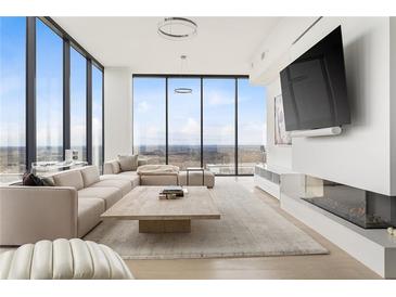 Bright living room featuring floor-to-ceiling windows and a modern fireplace beneath a large flat screen TV at 788 W Marietta St # 1809, Atlanta, GA 30318
