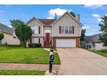 Charming two-story home with red shutters, two-car garage, green lawn, and inviting red front door at 335 Lee Miller Ct, Suwanee, GA 30024