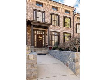Charming brick townhouse featuring a welcoming entrance and well-maintained landscaping at 1605 Ridenour Pkwy, Kennesaw, GA 30152