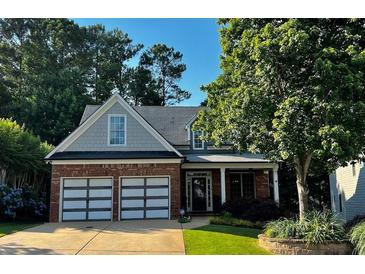 Charming brick home with a well-manicured lawn, featuring a two-car garage, inviting front porch, and mature trees at 81 Richmond Way, Villa Rica, GA 30180