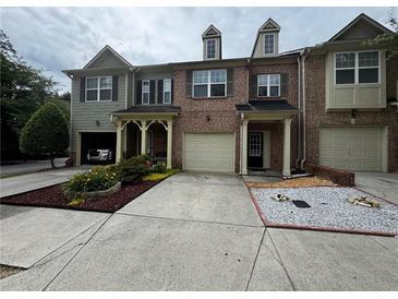 Charming townhome featuring brick facade, attached garage, and beautifully landscaped front yard at 1649 Southgate Mill Nw Dr, Duluth, GA 30096