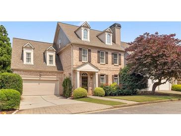 Charming brick two-story home with a well-manicured lawn and attached two-car garage at 1121 Vinings Grove Se Way, Smyrna, GA 30082
