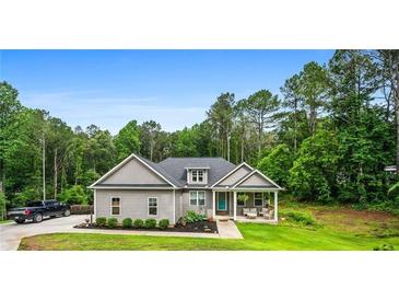 Charming single-story home with a manicured lawn and inviting front porch, set against a backdrop of lush trees at 190 Paul Aiken Rd, Dallas, GA 30157