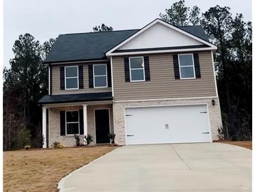Charming two-story home featuring a two-car garage, neutral siding, and black shutters on a cloudy day at 30 Barton Ln, Covington, GA 30016