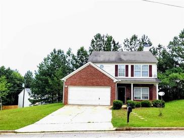 Charming two-story home featuring a brick facade, well-maintained lawn, and an attached two car garage at 6902 Malvern Ct, Stonecrest, GA 30038