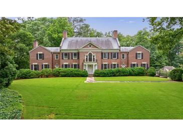 Stately brick home featuring lush front lawn, manicured landscaping, and balanced symmetrical design at 280 Blackland Nw Rd, Atlanta, GA 30342
